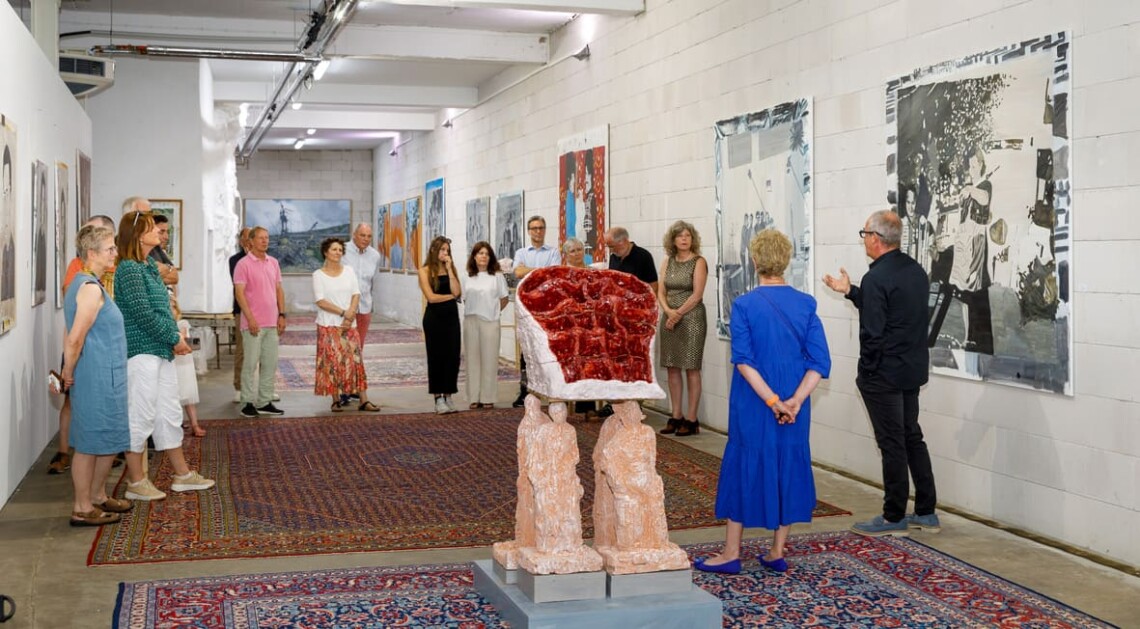 Presentazione del vernissage, accanto a una scultura bordeaux