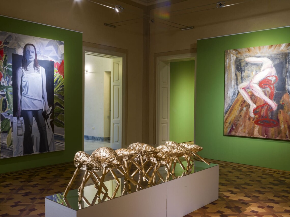 Sala della mostra Random di Giuseppe Donnaloia con dipinti di grande formato su pareti verdi e scultura dorata al centro